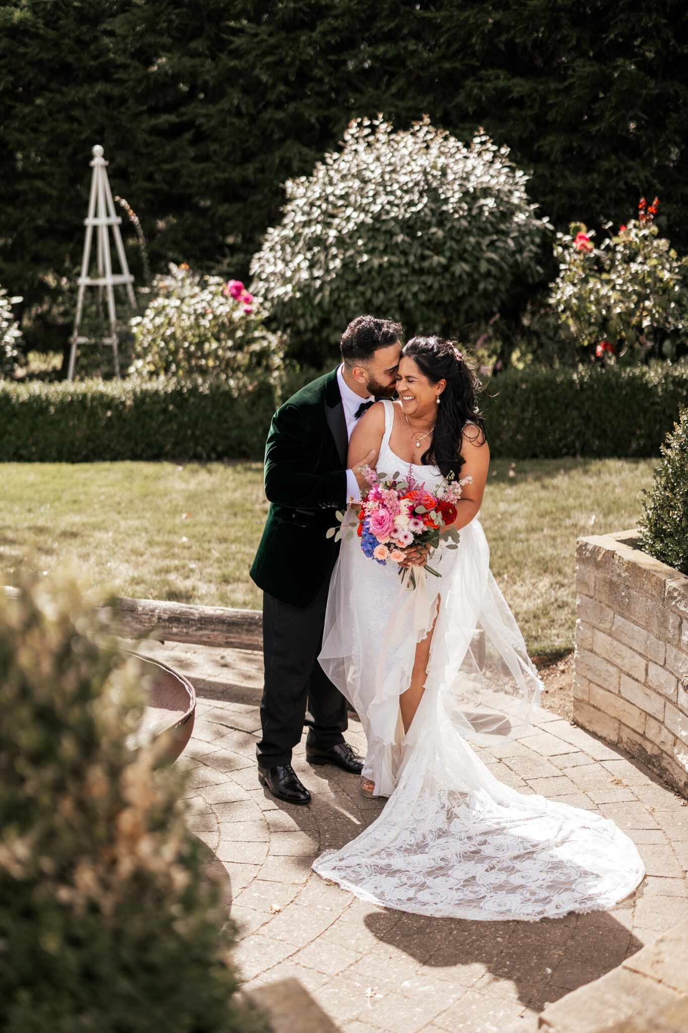 Newlyweds share a funny and romantic moment in the garden of a Kent wedding venue