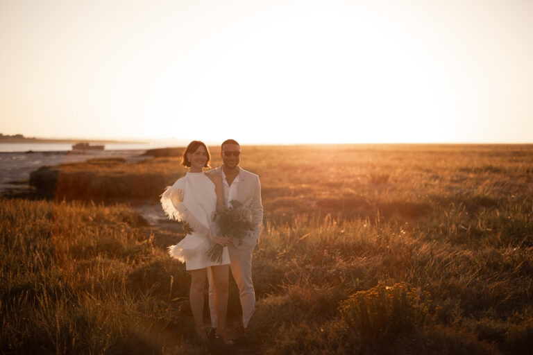 Twilight wedding portrait by the coast with golden grasses
