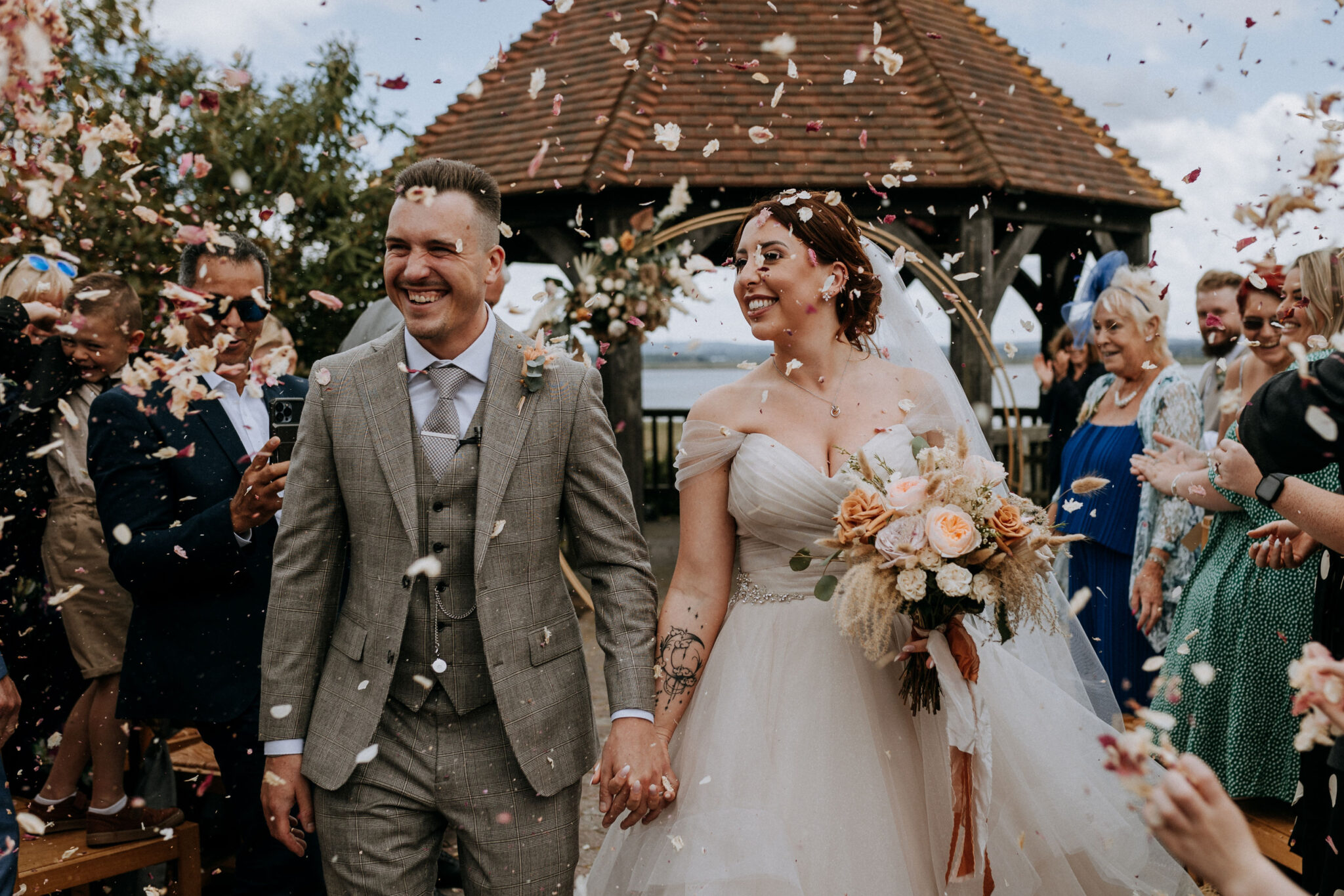 Wedding couple showered with confetti by happy guests