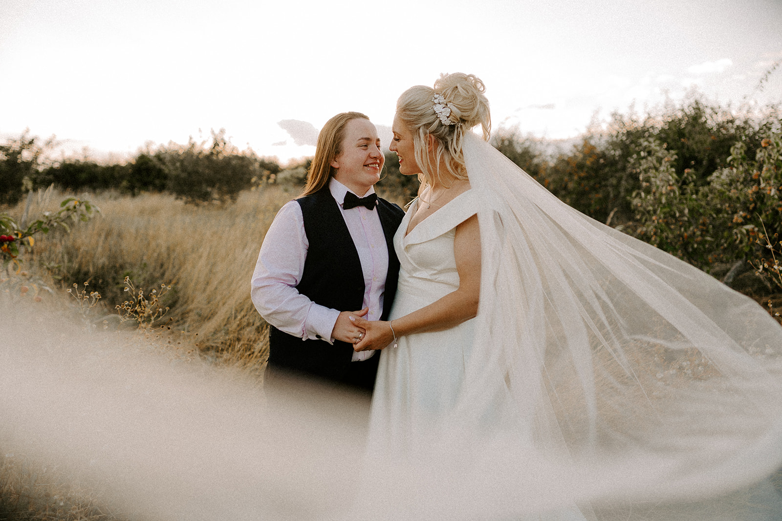 LGBT wedding couple share a tender moment in a Kent wedding venue orchard