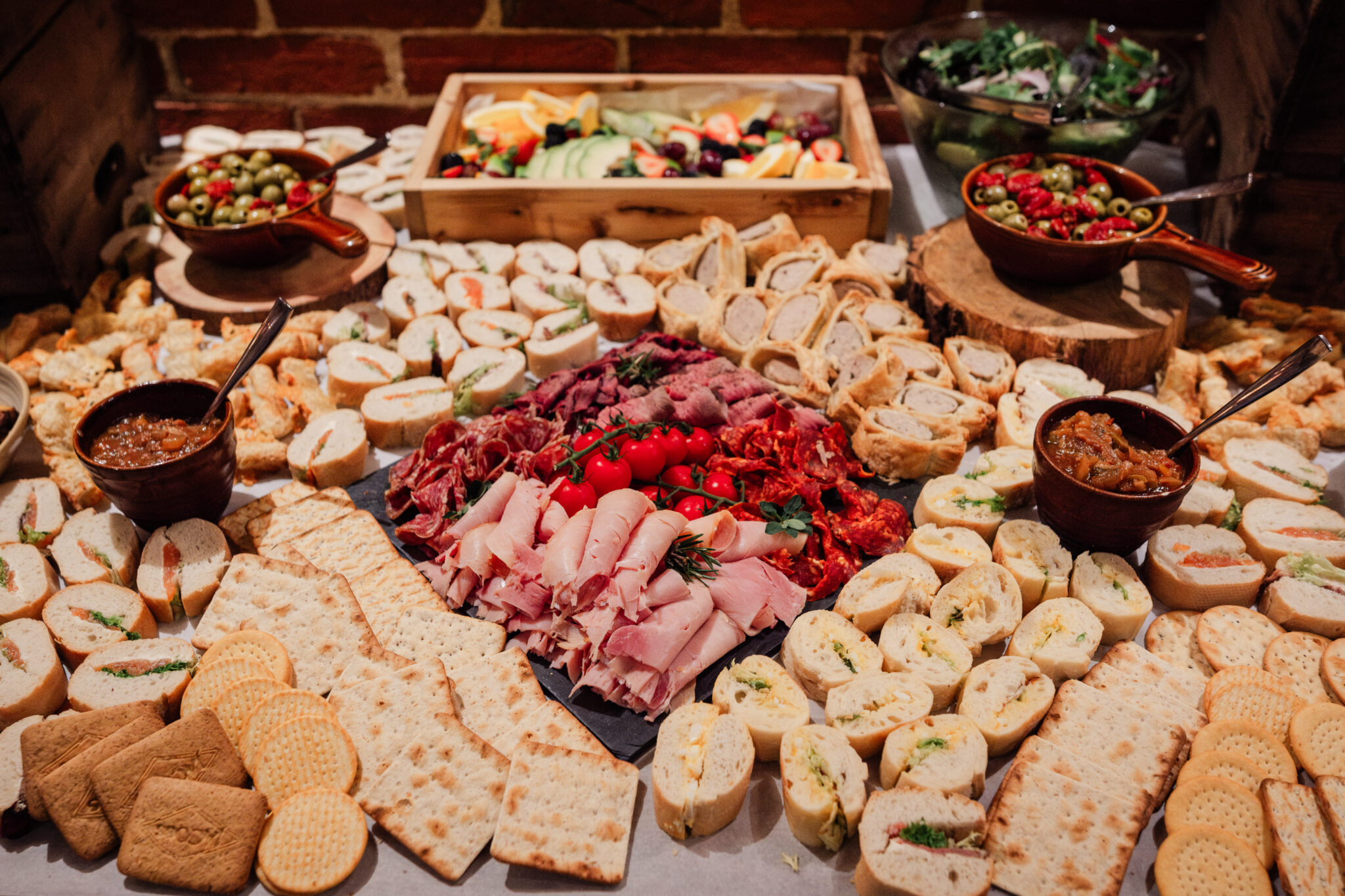 Generous gourmet grazing table spread served at a wedding barn