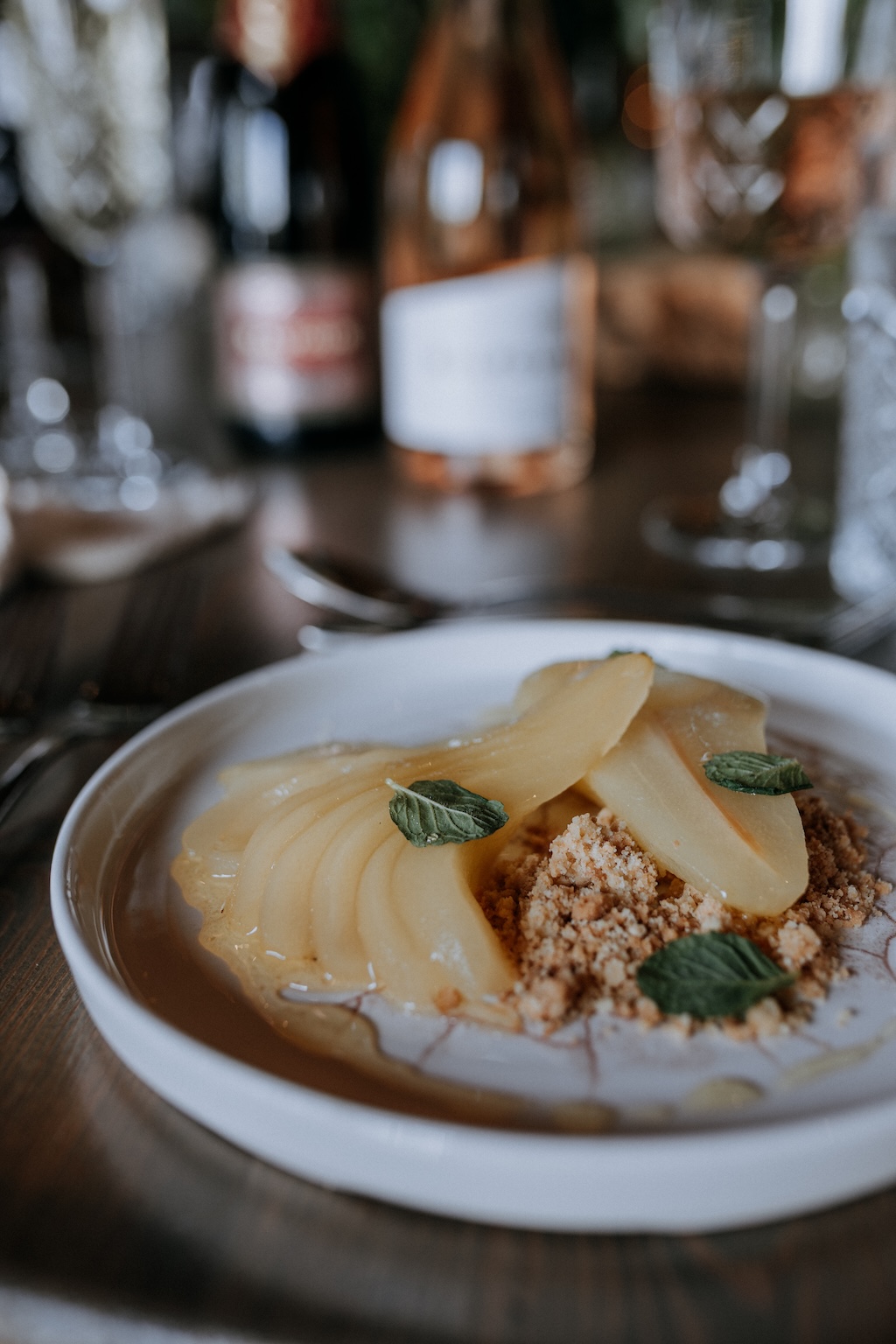 Wedding dessert plate featuring homegrown pear served on a rustic wooden table with Kent wine