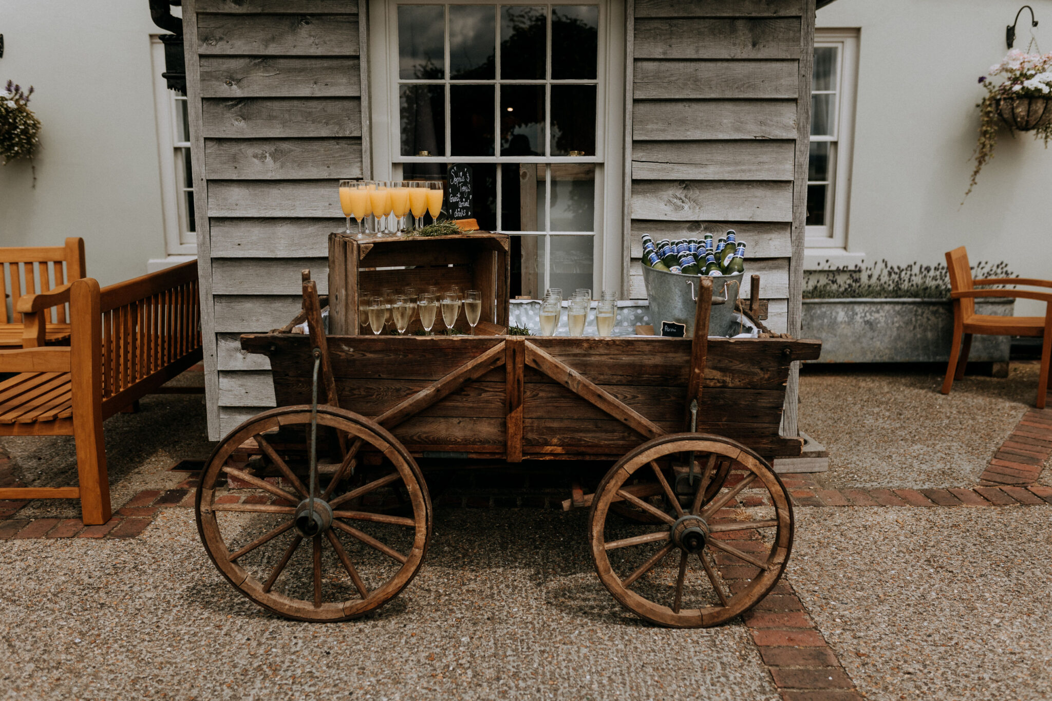 Charming wooden drinks cart serves rustic reception drinks at a country wedding venue