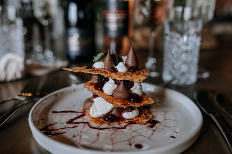 Impressive tiered wedding dessert with crispy pastry, berries, cream and chocolate mousse