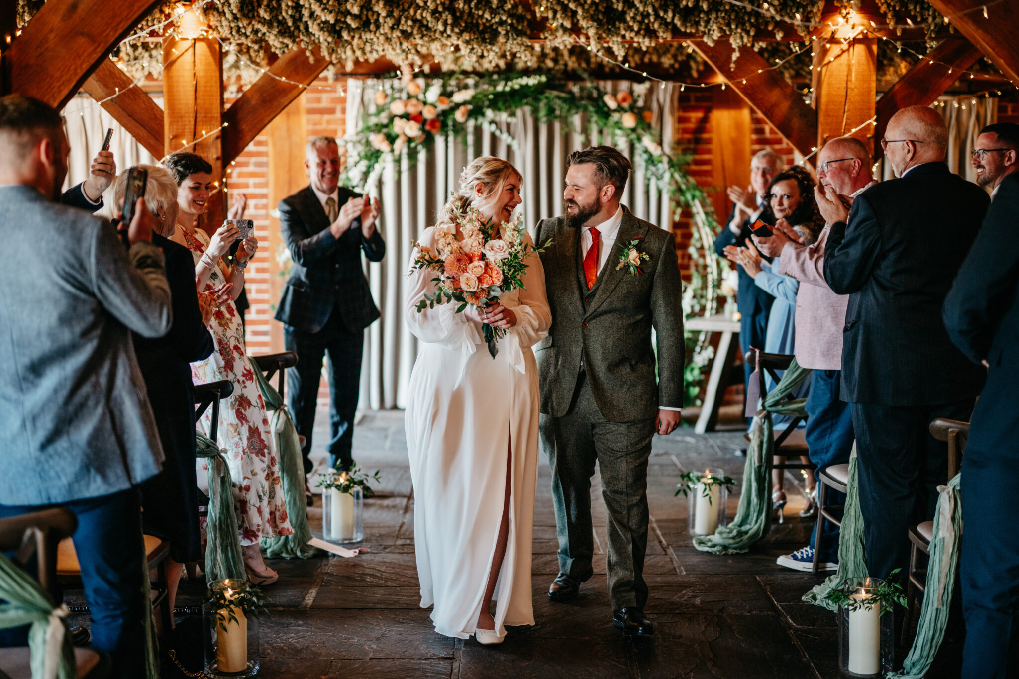 Happy newlyweds walking down the aisle after their barn wedding ceremony