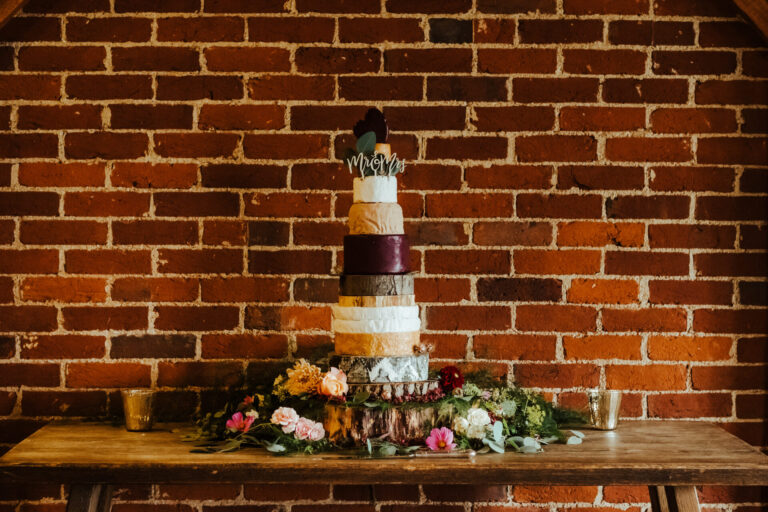 Stunning cheese tower dressed with flowers in a wedding barn