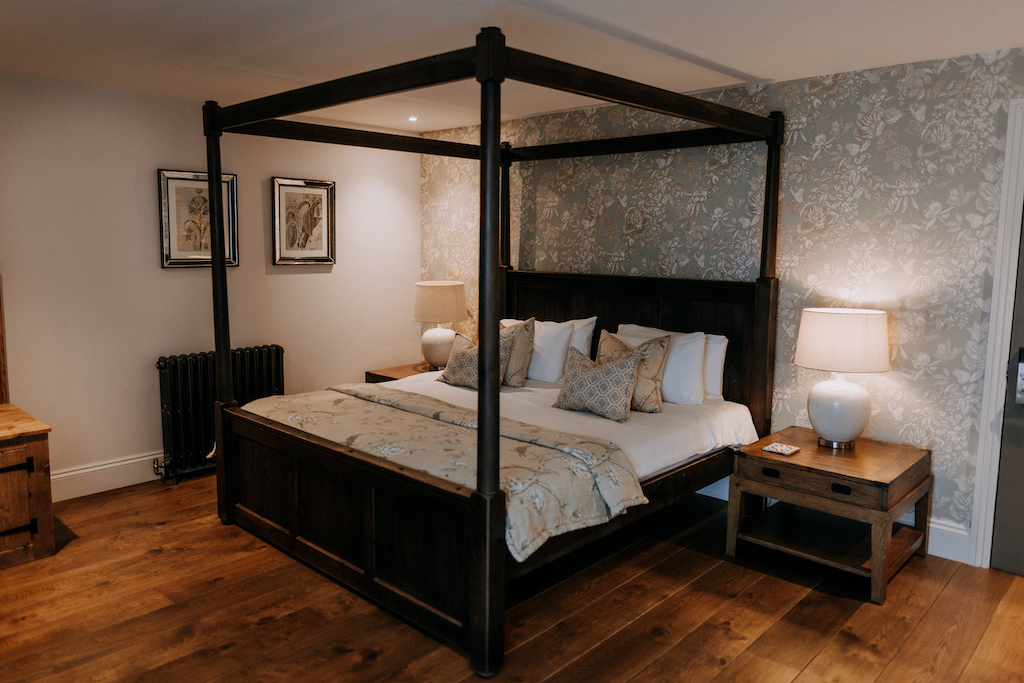 Four poster bed in a luxe guest room at The Harty Estate wedding venue