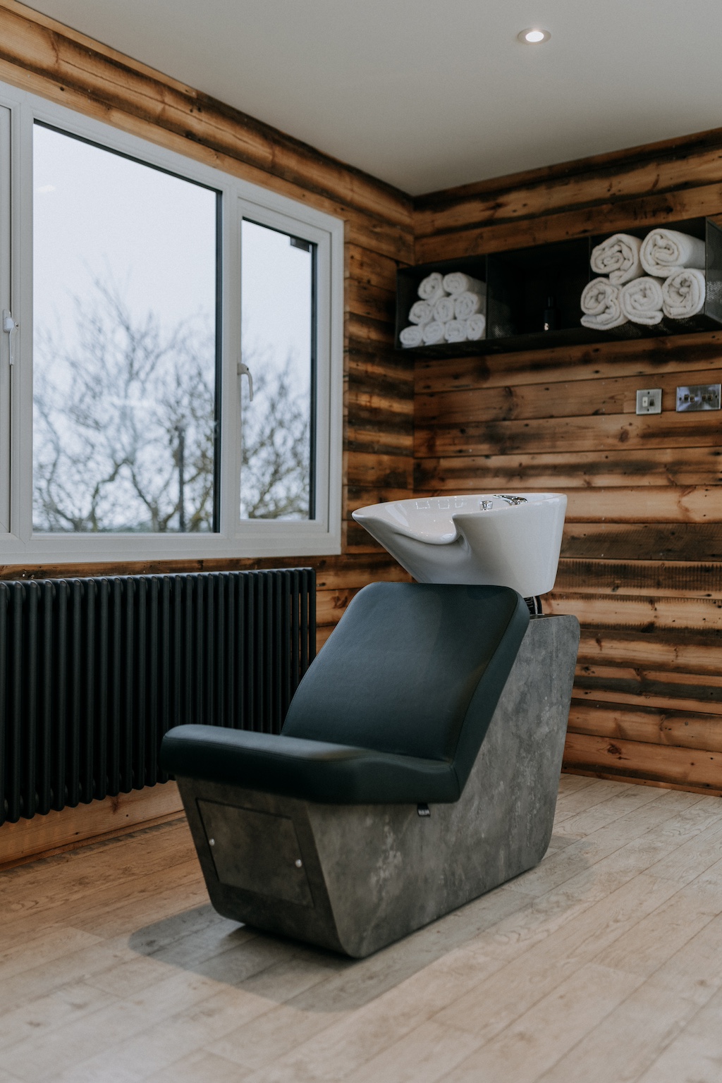 Hairwashing sink chair in a wood panelled, wedding venue getting ready room