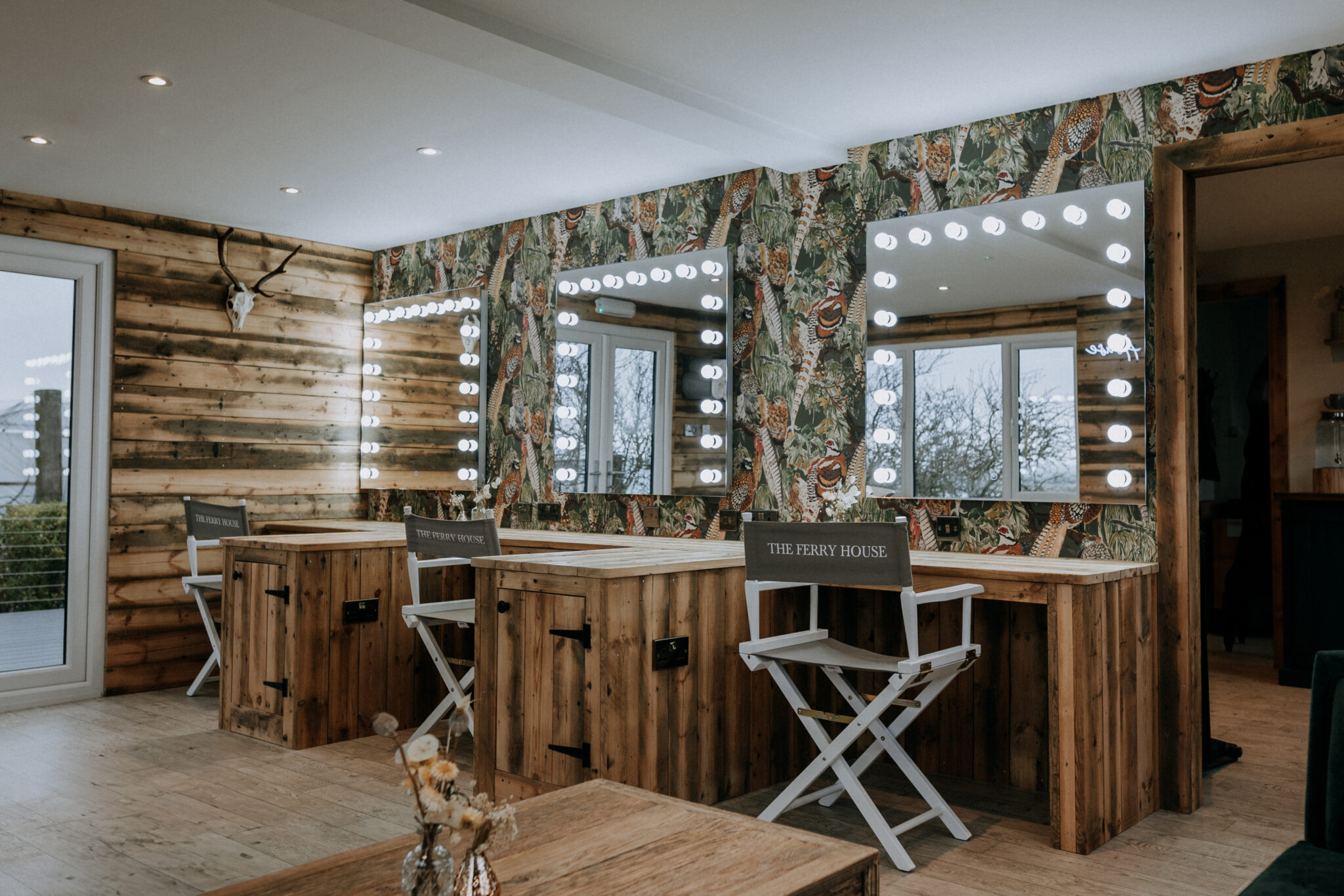 Three illuminated hair and make up stations in a wedding venue getting ready room
