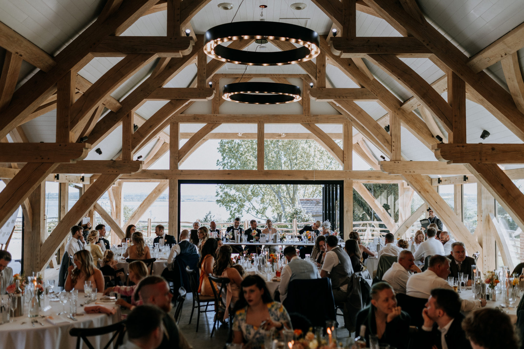 Guests enjoying a barn wedding reception overlooking the estuary in Kent