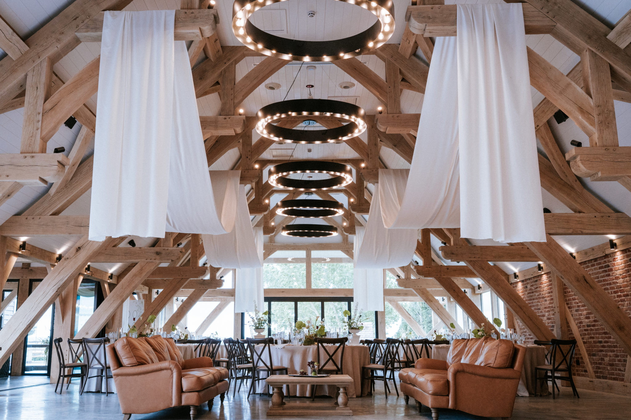 Barn wedding ceremony with flower-lined aisle and moongate