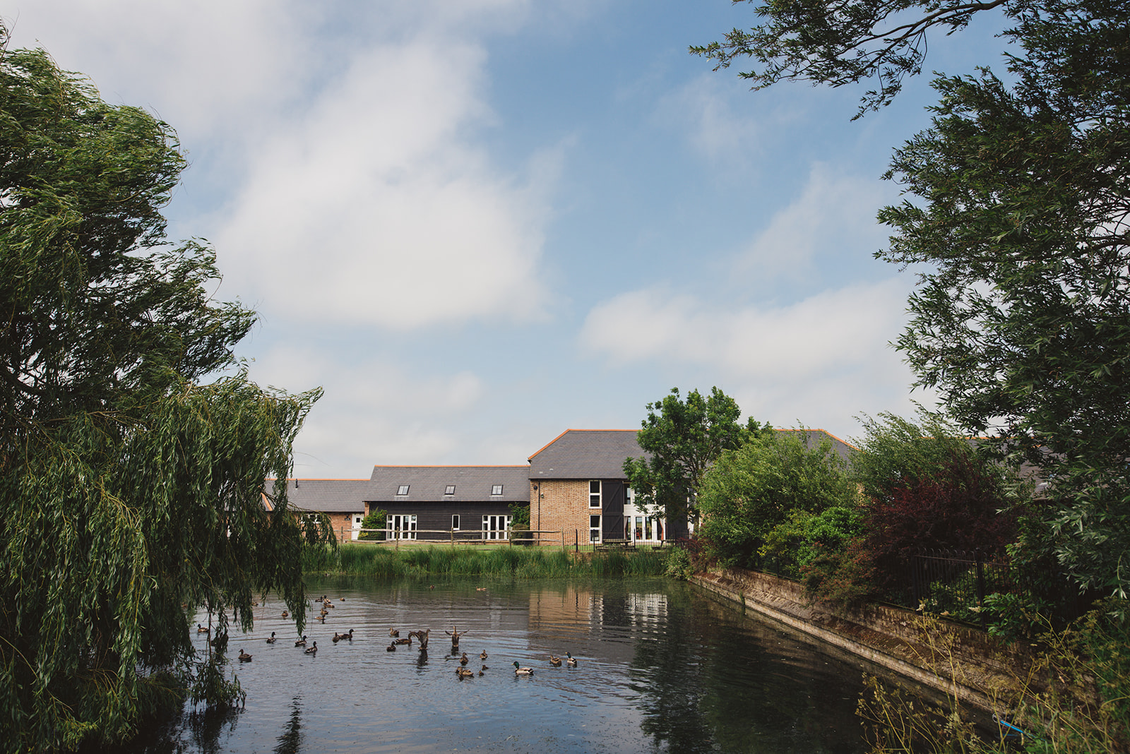Exterior of the Mocketts Farm Cottages overlooking a duck pond