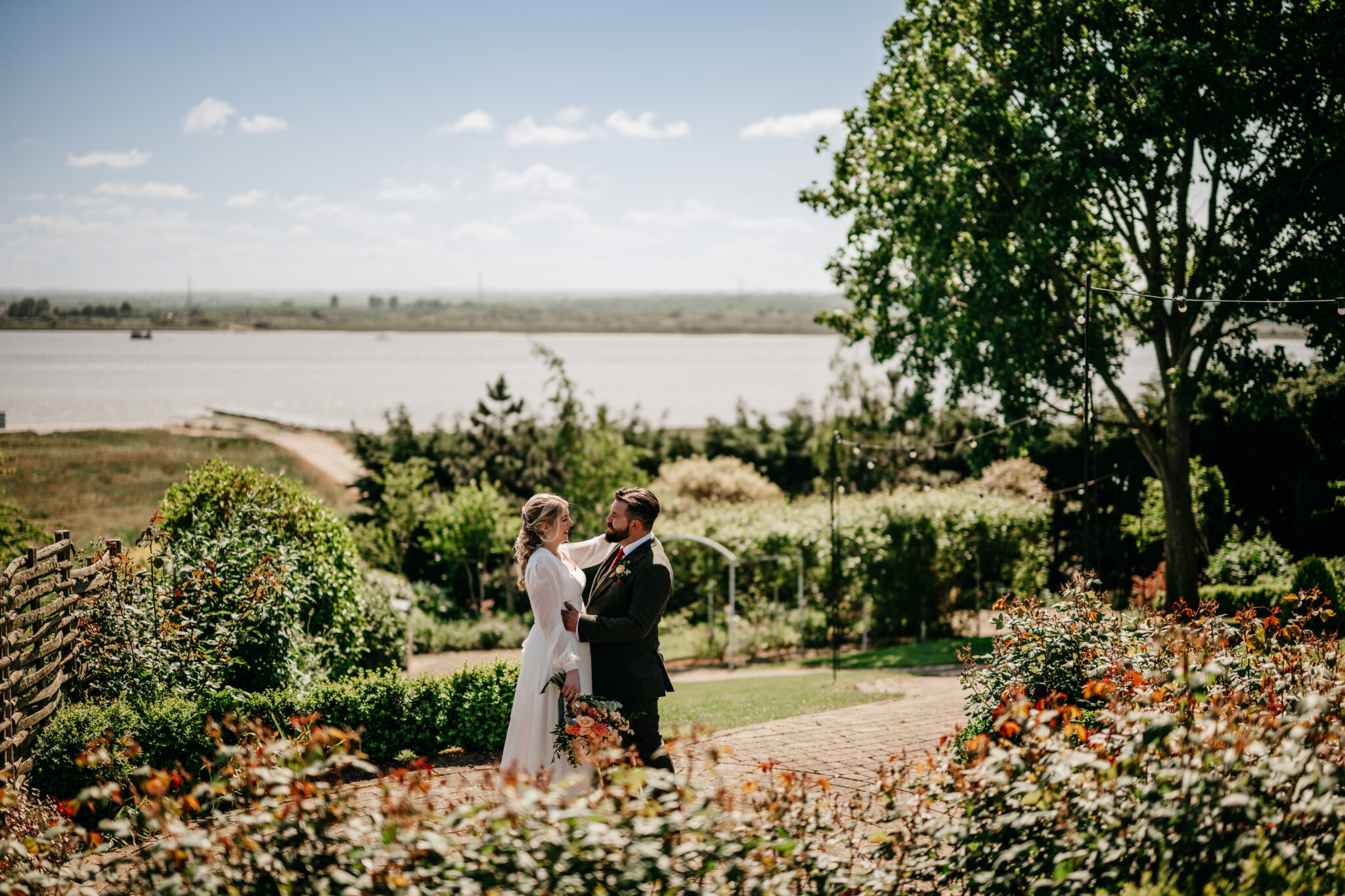 Newlyweds in the garden of The Harty Estate wedding venue, overlooking the estuary in Kent