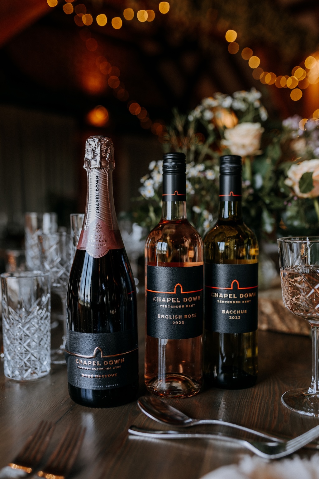Three bottles of Kent wine on a barn wedding breakfast table