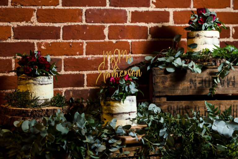 Deconstructed three tier rustic wedding cake dressed with foliage