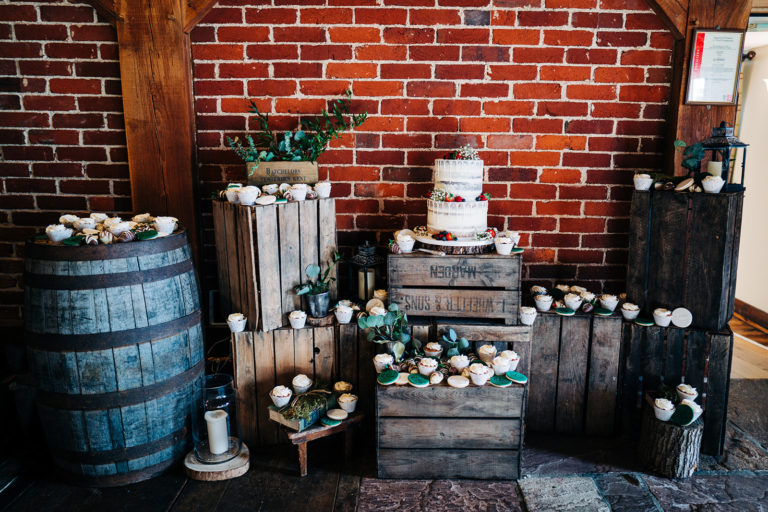 Wedding cake and cupcakes displayed on rustic apple crates