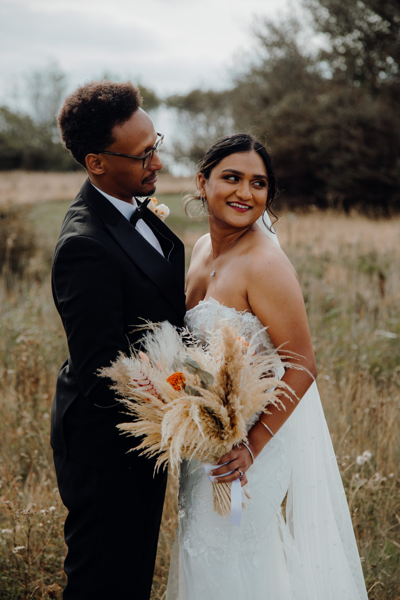 Newlyweds embracing to a country backdrop of grasslands in Kent