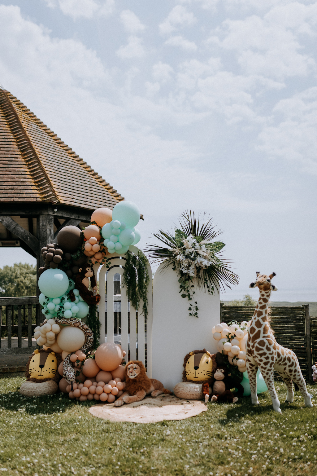 Event venue dressed with christening decor of soft toys, balloons and a backdrop
