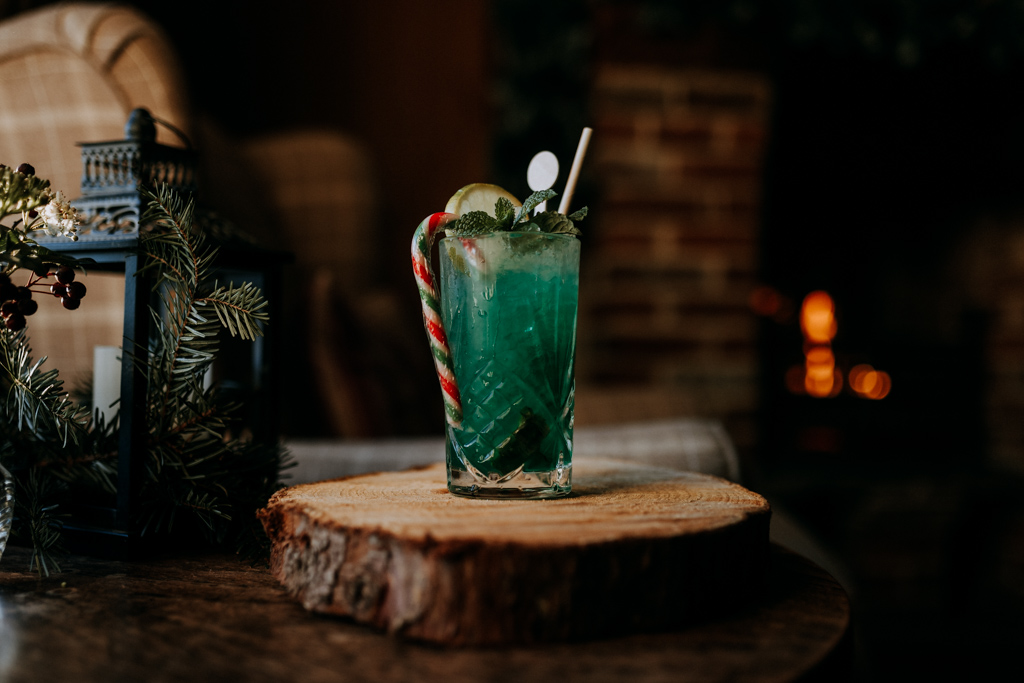 Green Christmas cocktial with candy cane garnish