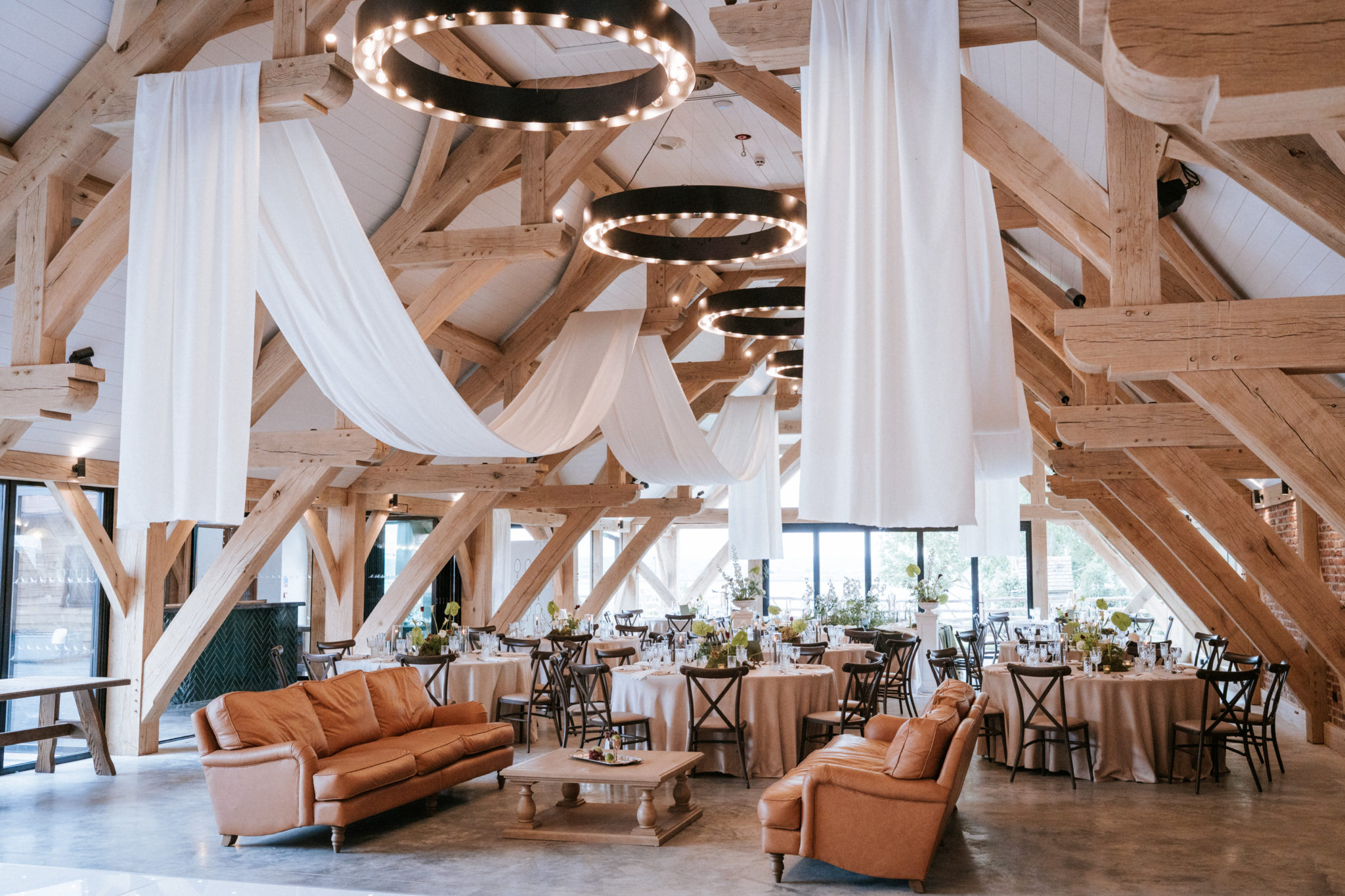 Barn wedding breakfast styled with ceiling draping